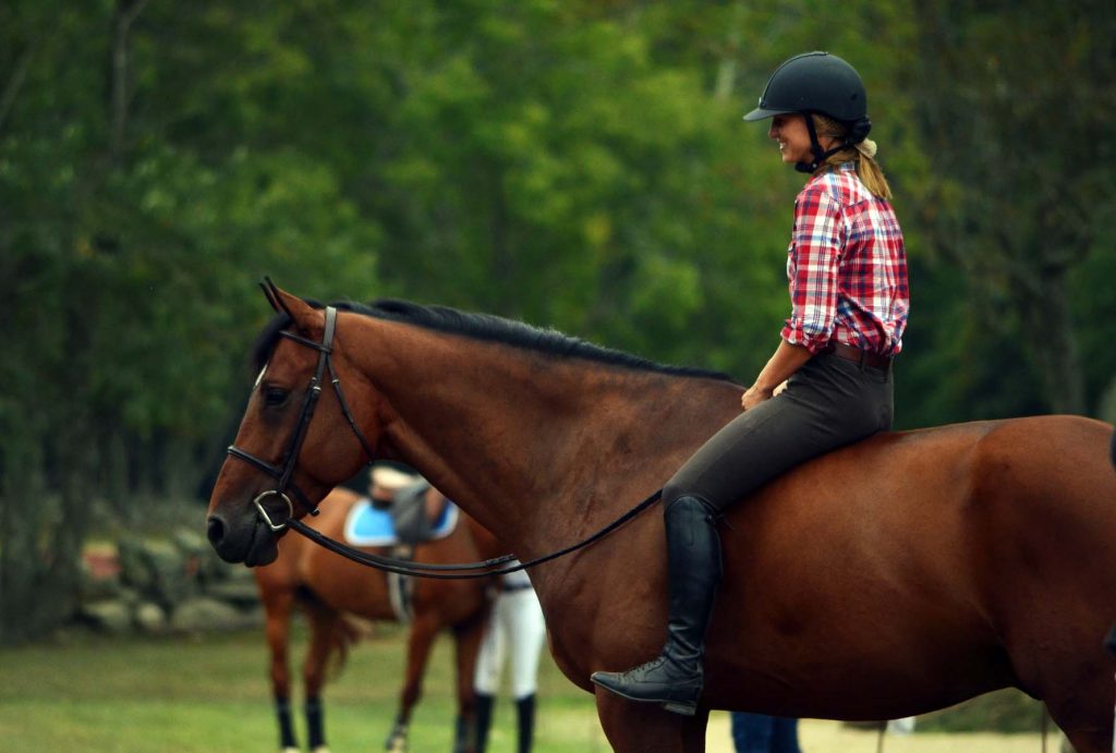 Girl riding bay horse bareback on a hot summer day.