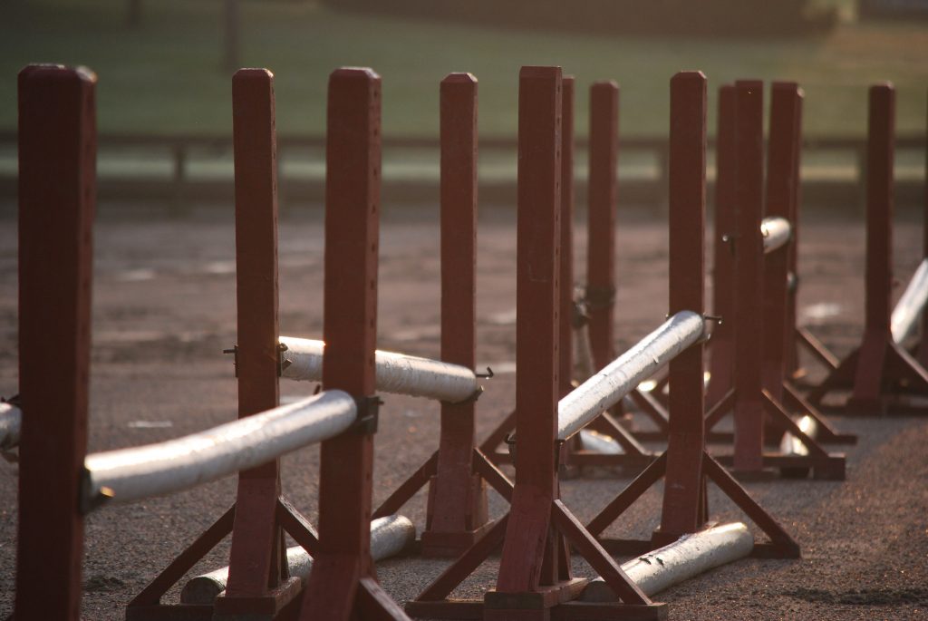 Several fences and jump posts set up for a gymkhana summer activity.
