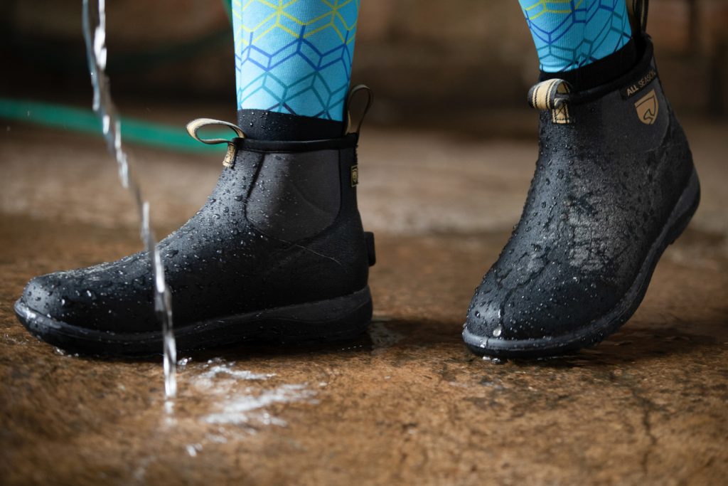 Noble Equestrian Perfect Fit All Season Low Boots in black being worn while hose water is running.