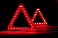 A pair of light up safety traffic triangles at night